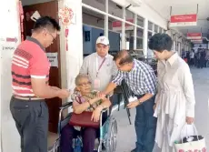  ??  ?? Dr Chan (second right) and Lorna (right) greet a voter on wheelchair at SMK Chung Hua in Miri.