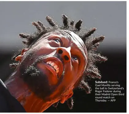  ??  ?? Subdued: France’s Gael Monfils serving the ball to Switzerlan­d’s Roger Federer during their Madrid Open third round match on Thursday. — AFP