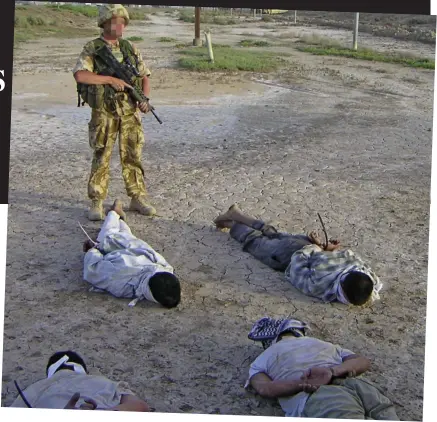  ??  ?? Combat: A soldier guards detainees in a picture released with the inquiry report