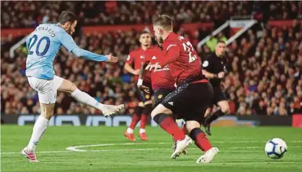  ?? REUTERS PIC ?? Manchester City’s Bernardo Silva (left) scores their first goal against Manchester United in a Premier League match at Old Trafford on Wednesday.