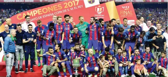  ?? ?? MADRID: Barcelona players and staff pose with the trophy at the end of the Spanish Copa del Rey (King’s Cup) final football match FC Barcelona vs Deportivo Alaves at the Vicente Calderon stadium in Madrid on Saturday. Barcelona won 3-1. — AFP