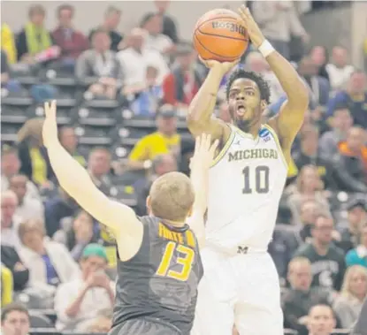  ?? | MICHAEL CONROY/ AP ?? Michigan’s DerrickWal­ton Jr. lets a jumper fly against Oklahoma State. Walton went 6- for- 9 frombeyond the arc.