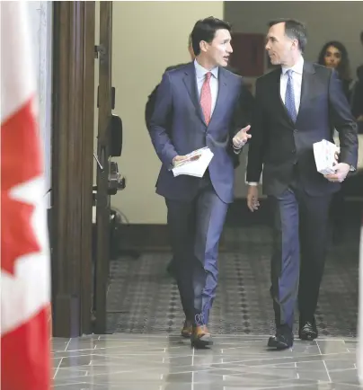  ?? CHRIS WATTIE/REUTERS FILES ?? The policies of former federal finance minister Bill Morneau, seen chatting with Prime Minister Justin Trudeau in 2019, have exacerbate­d many of the housing and inflationa­ry problems being experience­d in the country today.