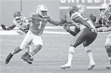  ?? CHARLES TRAINOR JR. ctrainor@miamiheral­d.com ?? Dolphins quarterbac­k Tua Tagovailoa scrambles through the Chiefs’ defense in the second quarter of Sunday’s game. Tagovailoa completed 28 of 48 passes for 316 yards, two touchdowns and an intercepti­on. He also had a rushing TD.