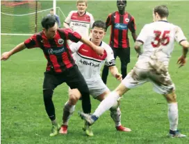  ??  ?? United’s Bryson Tanti is double teamed in this contest for the ball. The forward had his best game of the year as his side secured a 2-1 victory over Eltham.