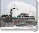  ?? AP ?? Rough seas pound harbor wall at Porthcawl in Wales as storm sweeps the U.K. Saturday.