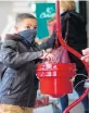  ?? VINCENT D. JOHNSON/POST-TRIBUNE ?? Jay Mandoza, 8, of Gary, makes a donation inside the Salvation Army kettle at the Strack & Van Til at 2635 169th St. in Hammond, on Wednesday.