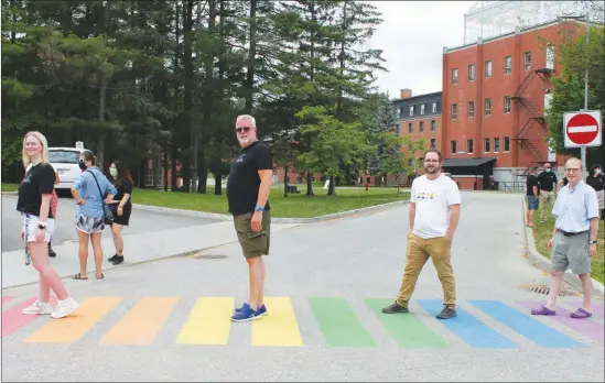  ?? GORDON LAMBIE ?? Bishop’s University Pride Alliance co-lead Gillian Maclean, Vice-principal Academic Miles Turnbull, Students’ Representa­tive Council President Enzo Evangelist­i, and Principal Michael Goldbloom make their way across the new rainbow crosswalk on campus.