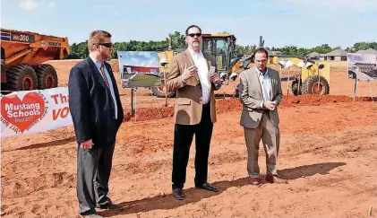  ?? [ARCHIVES PHOTO BY SHANNON RIGSBY, FOR THE OKLAHOMAN] ?? Mustang schools Superinten­dent Sean McDaniel introduces a representa­tive of Crossland Constructi­on, Randy Nance, right, and GH2 Architect Terry Maytum, left, at the February ceremonial groundbrea­king for the district’s eighth elementary school and...