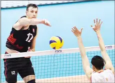  ??  ?? Gavin Schmitt (left), of Canada spikes the ball over Zhong Weijun (right), of China during the men’s volleyball world final qualificat­ion for the Rio de Janeiro
Olympics 2016 in Tokyo on June 5. (AFP)