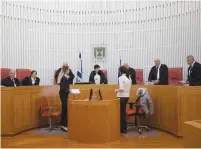  ?? (Flash90) ?? SUPREME COURT President Miriam Naor (center) and other justices speaks with staff in Jerusalem.