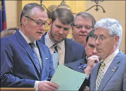  ?? HYOSUB SHIN / AJC ?? Lt. Gov. Casey Cagle (left) confers with Sen. Bill Heath (right) and other senators over a bill Friday, which was Crossover Day, the final day for a bill to move from one chamber to the other this year. The most high-profile bill of the day was one...