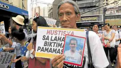  ??  ?? RIGHTS DENIED Holding a placard with her kin’s picture, this woman joins the Human Rights Day rally on Tuesday at the Sta. Cruz Church. —JOAN BONDOC