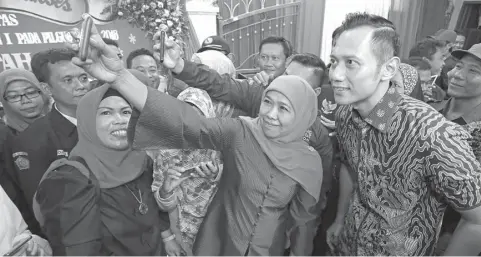  ?? GALIHCOKRO/JAWA POS ?? UCAPKAN SELAMAT: Khofifah Indar Parawansa berswafoto dengan Agus Harimurti Yudhoyono yang berkunjung ke kediaman mantan menteri sosial itu di Surabaya kemarin.