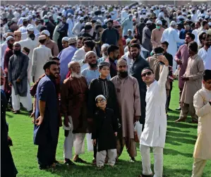  ?? — AP, APP ?? EID AMID PANDEMIC: A family takes a selfie after attending Eid Al Fitr prayers at a ground in Karachi on Sunday; people offer Eid prayers in Hyderabad while wearing masks to protect against coronaviru­s, and a man buys a balloon for his daughter after Eid prayers in Rawalpindi.