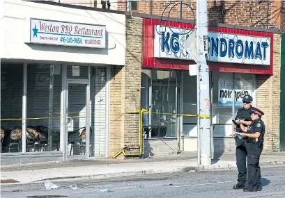  ?? ANDREW FRANCIS WALLACE TORONTO STAR ?? Police look over a scene where a man in his 30s was stabbed to death early Friday on Weston Rd., south of Lawrence Ave. W.