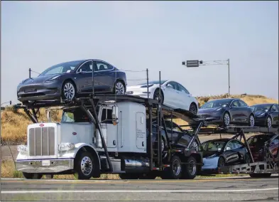  ?? (Bloomberg/Nina Riggio) ?? An auto transport trailer carries Tesla Inc. electric vehicles outside the company’s factory in Fremont, Calif., last week.