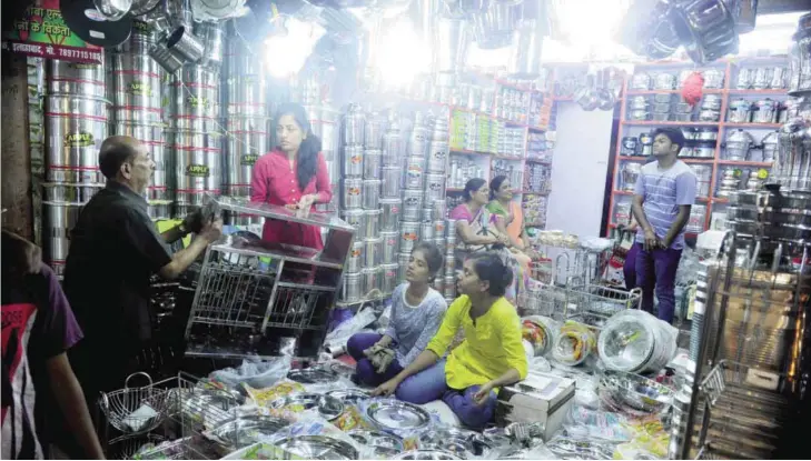  ?? AFP ?? ALLAHABAD: Indian customers shop for utensils during the Dhanteras festival yesterday. Hindus consider it auspicious to purchase gold, silver and utensils during Dhanteras. —