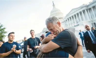  ?? DREW ANGERER/GETTY ?? Comedian and activist Jon Stewart hugs Rosie Torres, wife of veteran Le Roy Torres, who suffers from illnesses related to his exposure to burn pits in Iraq, after the Senate passed the PACT Act on Tuesday in Washington, D.C.