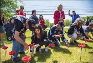  ?? SUBMITTED ?? Members of American Legion Post 211plant ceramic poppies in front of their post before Memorial Day 2022.