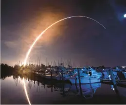  ?? MALCOLM DENEMARK/FLORIDA TODAY ?? NASA’s new moon rocket lifts off early Wednesday from the Kennedy Space Center in Cape Canaveral, Fla., as seen from a marina on Merritt Island.