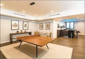  ??  ?? AMONG THE AMENITIES in the contempora­ry home are a game room, gym, media room, wine cellar and swimming pool.