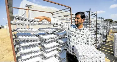  ?? —REUTERS ?? EGG-CYCLED Akram Al-Amour collects egg trays newly made from recycled paper waste at his factory, in Khan Younis, the Gaza Strip, on Nov. 10.