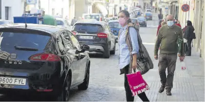  ?? JOSÉ ANTONIO AGUILAR ?? Una vecina trata de cruzar de acera en la calle Puerta de Aguilar, una de las vías con más tráfico rodado.