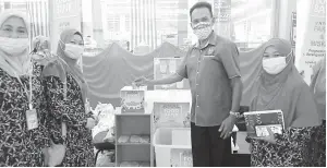 ??  ?? SUMBANGAN: Otoh Sibik menyumbang ke Tabung Amal Food Bank sambil diperhatik­an oleh Aida (kanan).