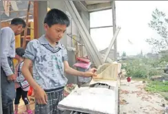  ?? PROVIDED TO CHINA DAILY ?? A boy finds his textbook after the disaster in Funing.