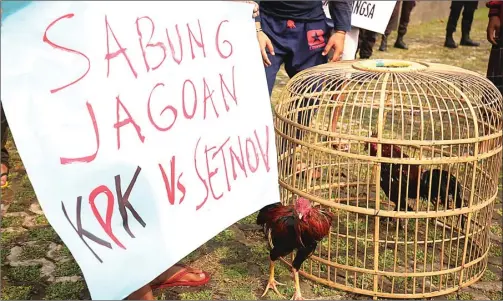  ?? IMAM HUSEIN/JAWA POS ?? PERANGI KORUPSI: Komunitas Cinta Bangsa melakukan aksi teatrikal dengan membawa ayam untuk menyimbolk­an KPK dan Setnov di depan gedung KPK, Jakarta, kemarin (21/4). Mereka meminta dan mendukung lembaga antirasuah itu untuk terus mengusut tuntas dugaan...