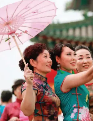  ??  ?? A cheongsam show on the ancient wall of Zhengding County. by Zhan Xincheng/xinhua