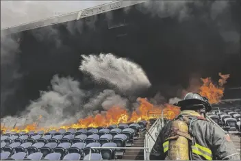  ?? DENVER FIRE DEPARTMENT VIA AP ?? IN THIS PHOTO PROVIDED BY THE DENVER FIRE DEPARTMENT, firefighte­rs battle flames at Empower Field at Mile High stadium in Denver on Thursday.