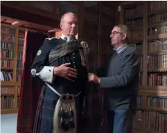  ??  ?? Right: Graham Jack in his full uniform in the library at Blair Castle. Above: Keith Todhunter, the Highlander­s’ Regimental Quartermas­ter Sergeant, helps Graham put on his plaid.