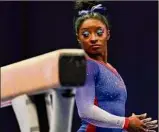  ?? Jeff Roberson / Associated Press ?? Simone Biles looks back at the balance beam Friday. Biles had the top score on the apparatus in the U.S. Olympic Trials.