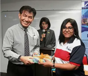  ??  ?? Gladys presenting a souvenir to Aslam Khan.