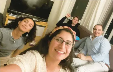  ?? CATALINA MARIA GOMEZ CAYCEDO ?? Henry Crabtree, back right, has plenty of reason to toast in his London apartment. He met friends Michael Watkins, Catalina Maria Gomez Caycedo and Aleena Rupani at work at a software company that has workers scattered around the world.