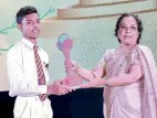  ?? ?? Second place winner, Kusal Sachintha, accepts his award from Education Ministry Director Humanities and National Languages Jayani Tillakarat­ne