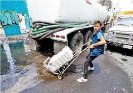  ??  ?? Un joven acarrea agua en un