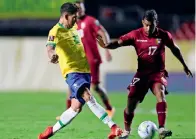  ?? AFP ?? TIGHT CONTEST: Brazil’s Firmino (left) and Venezuela’s Casseres vie for the ball during their World Cup qualifier match. —