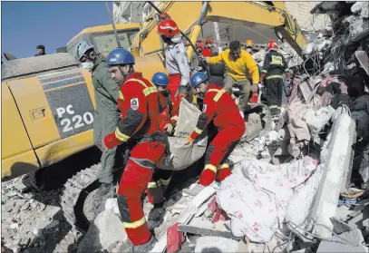  ?? Vahid Salemi ?? The Associated Press Rescuers on Tuesday carry away the body of an earthquake victim in Sarpol-e-zahab, Iran. Rescuers are digging through the debris of buildings felled by a Sunday temblor that killed more than 530 people in the border region of Iran...