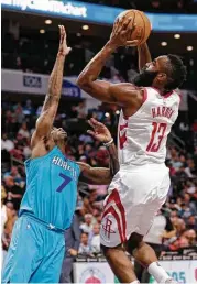  ?? Chuck Burton / Associated Press ?? Rockets guard James Harden shoots over the Hornets’ Dwayne Bacon on his way to a triple-double — 27 points, 10 rebounds and 11 assists.