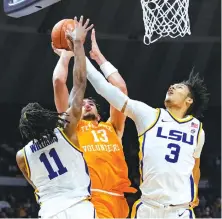  ?? AP PHOTO/MATTHEW HINTON ?? Tennessee’s Olivier Nkamhoua (13) shoots against LSU’s Alex Fudge and Justice Williams during the first half of Saturday’s game in Baton Rouge, La. LSU beat No. 18 Tennessee 79-67 as the Vols fell to 10-4 overall.