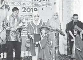  ??  ?? SETIPIKIT TEMBU SEKULA: Fatimah nyuaka setipikit ngagai siku nembiak SeDidik maya pengerami Konvokesye­n SeDidik Zon Kuching Ke-28, 2019 di Kuching, kemari. Bisi mega dipeda iya nya Direktor Besai SeDidik, Nor Ashikin Abdul Rahman (dua ari kanan).