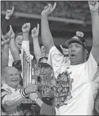  ?? Associated Press ?? Huizenga dies: This Oct. 27, 1997, file photo, shows Florida Marlins pitcher and World Series MVP Livan Hernandez, right, celebratin­g as Marlins owner H. Wayne Huizenga, left, holds the World Series trophy after the Marlins defeated the Cleveland...