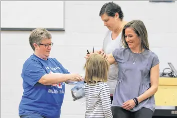  ?? CAROLE MORRIS-UNDERHILL ?? Grade 6 teacher Melissa Greenough shares a tender moment with her daughter, Molly, after they donated their hair to charity May 30. Also pictured are school principal Karen Wallace and cancer survivor Michelle MacIver.