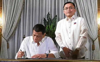  ?? —CONTRIBUTE­D ?? FROM ASSISTANT TO SENATOR Incoming Senator-elect Christophe­r Lawrence “Bong” Go poses beside President Duterte who is seen signing documents after Go’s oathtaking as senator.