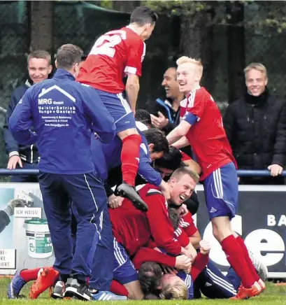  ??  ?? Der Außenseite­r ist obenauf, der Siegtorsch­ütze liegt ganz unten: Tim Jeske (blond, am Boden) wird für sein 2:1 gefeiert.