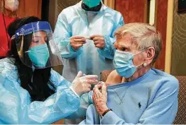  ?? Stephen Dunn / Associated Press file ?? In December 2020, Mary Lou Galushko gives Jeanne Peters, 95, a COVID-19 vaccine shot at The Reservoir nursing home in West Hartford, Conn.