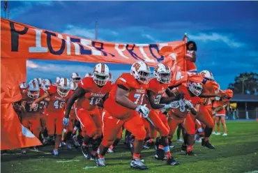  ?? PHOTO BY CADE DEAKIN ?? East Ridge football players run onto the field before a home game against Signal Mountain last Sept. 27.